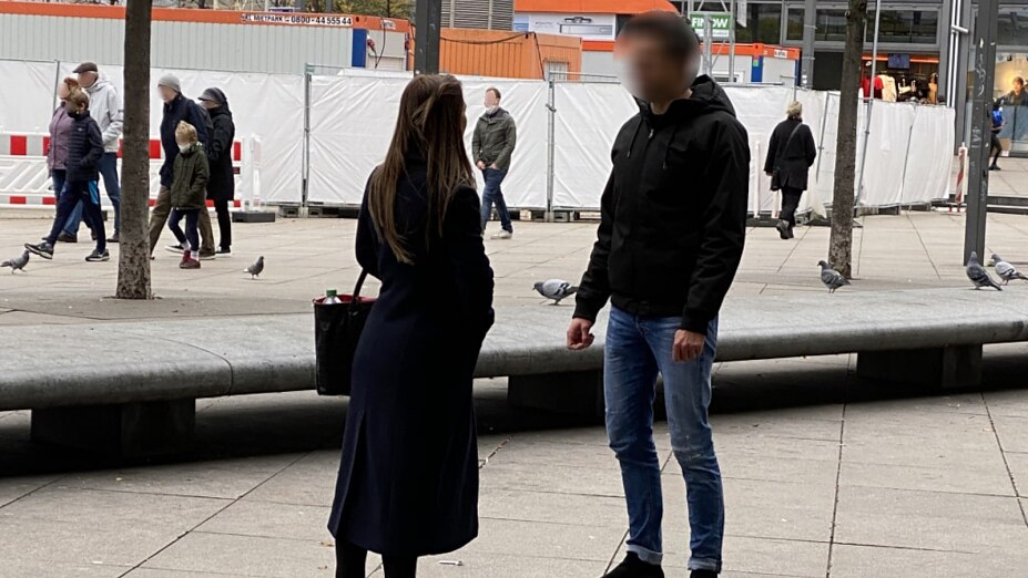 Coaching-Teilnehmer spricht Frau auf der Straße an