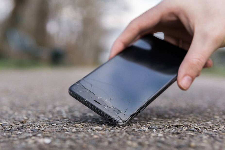 cropped-hand-holding-broken-smart-phone-road-freepik-bild-3