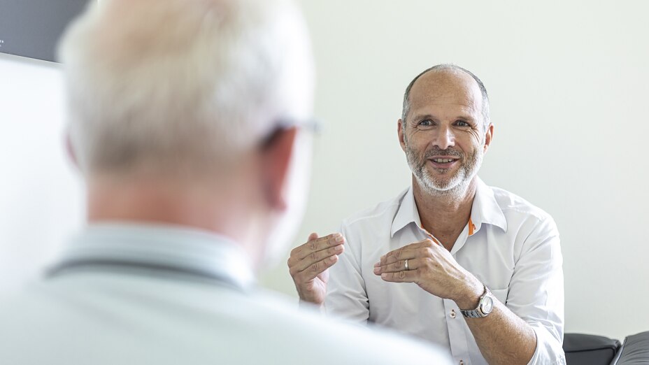 Betriebsarzt Dr. Walter Russ im persönlichen Beratungsgespräch mit einem Mitarbeiter – arbeitsmedizinische Betreuung für Unternehmen in München