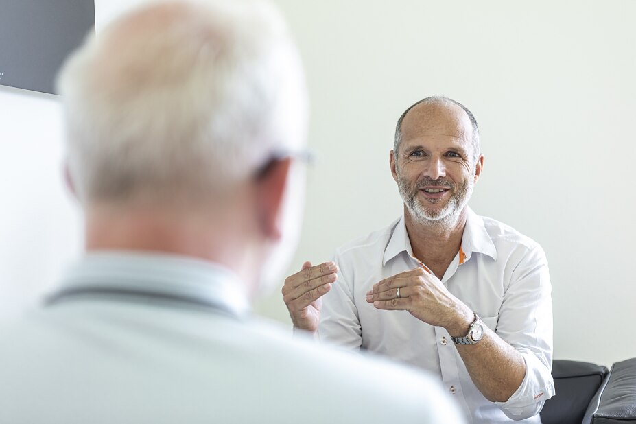 Betriebsarzt Dr. Walter Russ im persönlichen Beratungsgespräch mit einem Mitarbeiter – arbeitsmedizinische Betreuung für Unternehmen in München