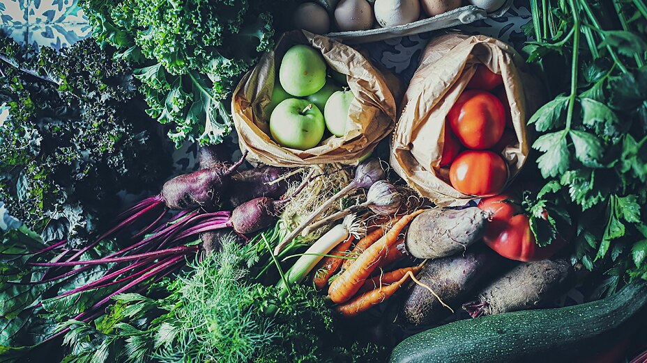 Obst und Gemüse, welches frisch vom Markt gekauft wurde. Äpfel, Tomaten, rote Rüben, Zucchini, Karotten, Sellerie und mehr