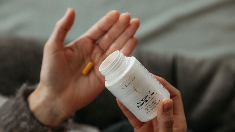 Vitamin B Komplex Dose und Kapsel auf Hand