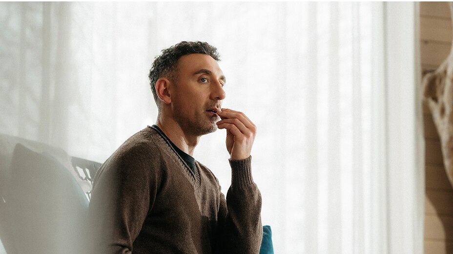 Mann nimmt Vitamin B Komplex Kapsel ein