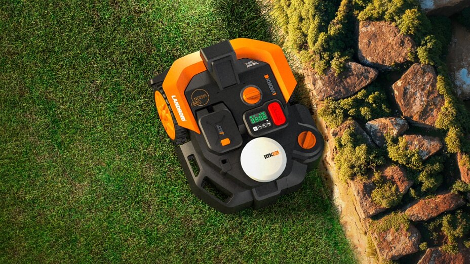 Draufsicht: WORX Landroid Vision Mähroboter beim kantennahen Mähen direkt an einer Natursteinbegrenzung.