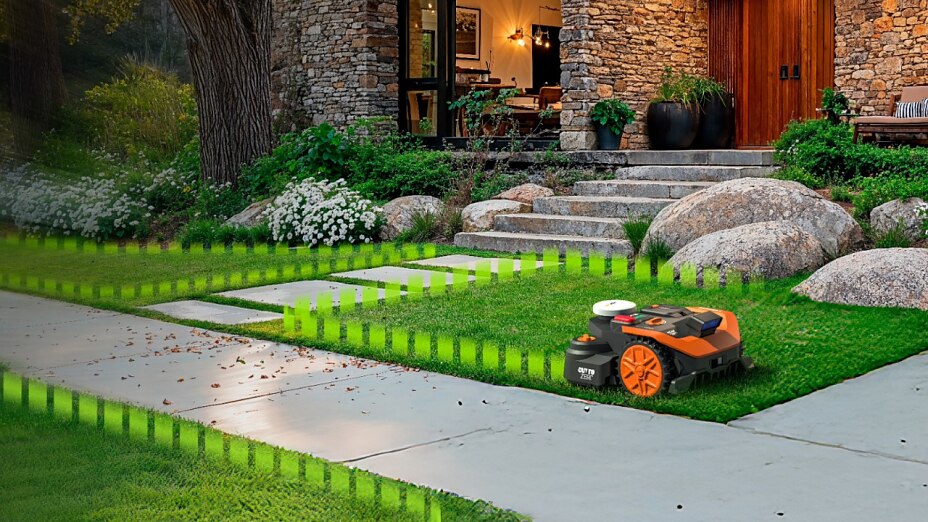 WORX Landroid Vision Mähroboter auf Rasen mit visualisierten grünen virtuellen Begrenzungslinien vor einem modernen Steinhaus.