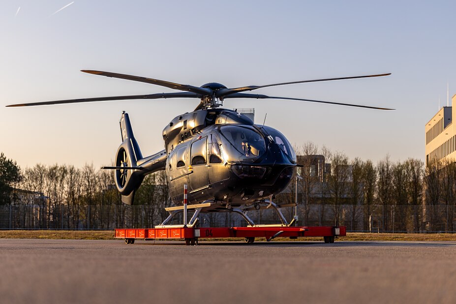 schwarzer VIP Hubschrauber steht auf roter Plattform im Sonnenuntergang