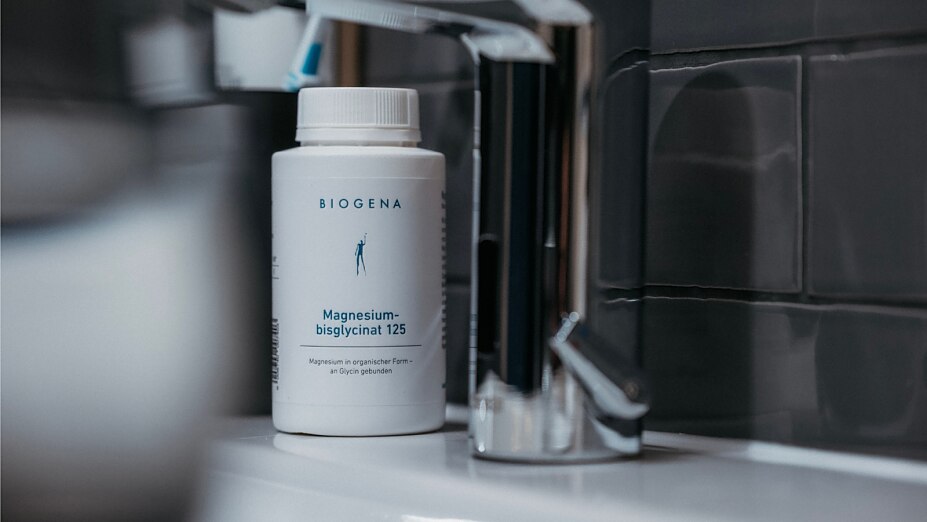Dose BIOGENA Magnesiumbisglycinat 125 steht neben einem Waschbecken.