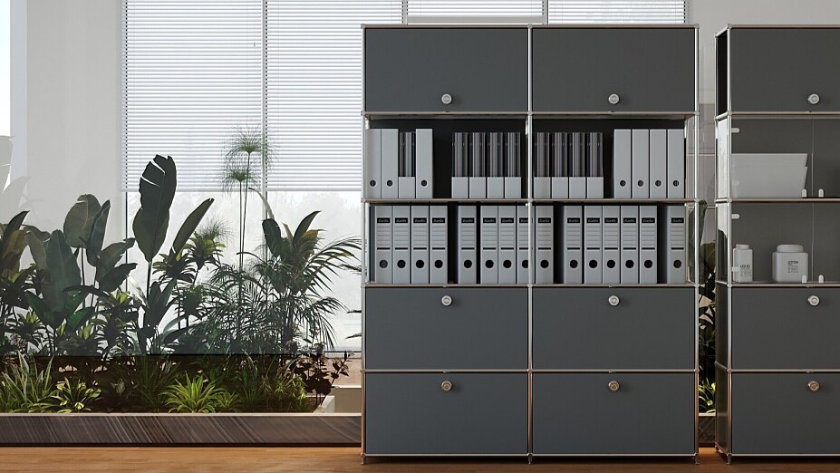 Modulares Flexcube Regalsystem in Dunkelgrau mit Klappen und offenen Fächern voller Ordner in einem hellen Büro