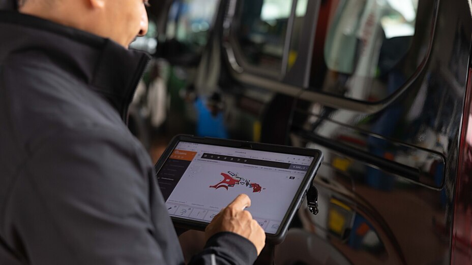 Kfz-Sachverständiger in München dokumentiert einen Fahrzeugschaden mit dem Tablet in der Werkstatt